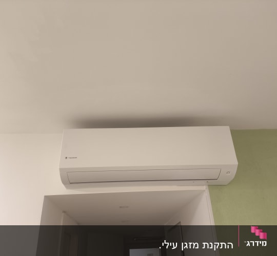 מזגן מותקן על קיר בחדר עם קיר ירוק